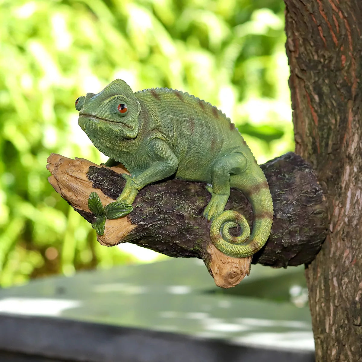 Figurine de caméléon en résine sur l'arbre